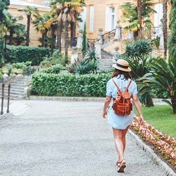 girl with backpack walking in tourist spot